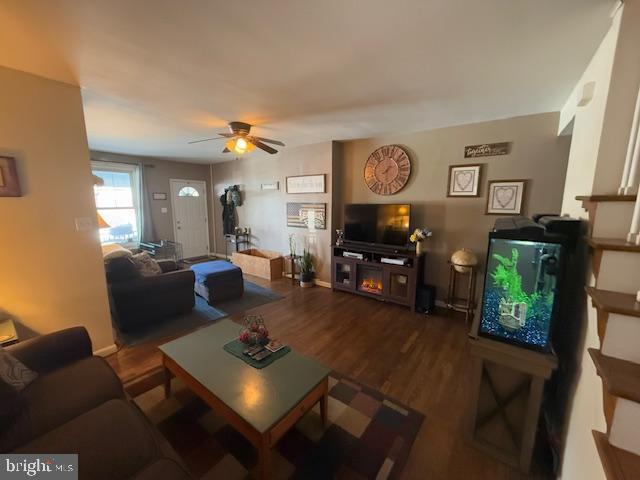 living room with dark wood-type flooring and ceiling fan