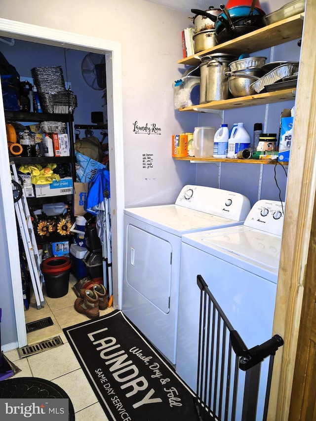 washroom featuring washing machine and dryer and light tile patterned floors