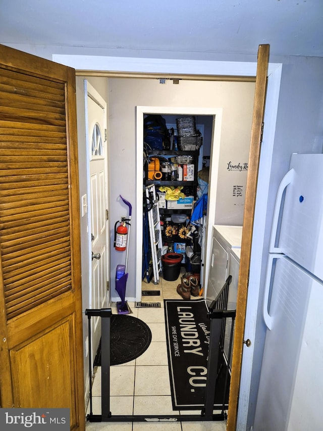 laundry area featuring light tile patterned floors and washer and clothes dryer