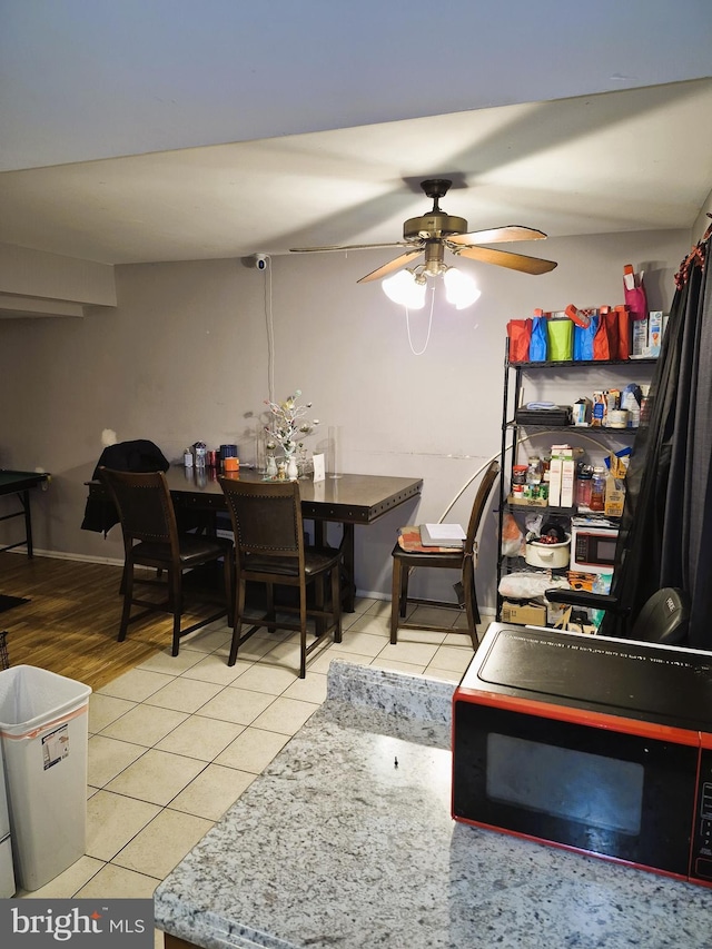 tiled dining space featuring ceiling fan