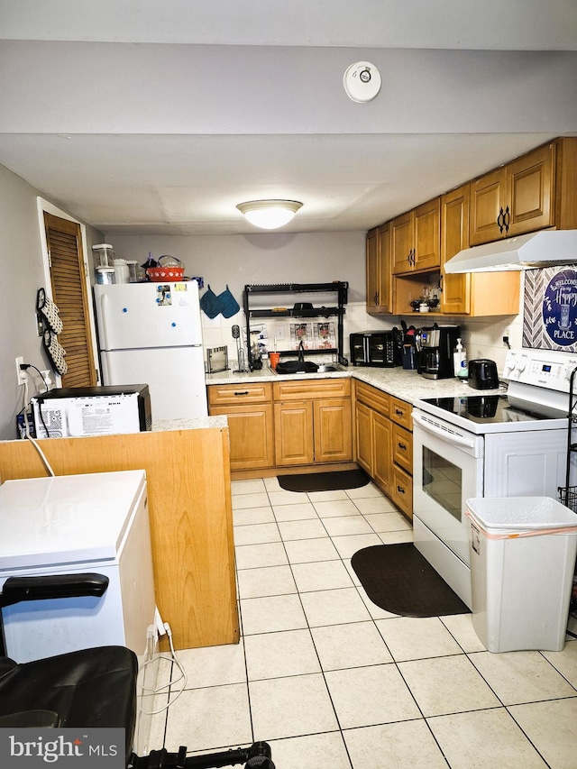 kitchen featuring sink, white appliances, and light tile patterned flooring