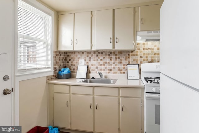 kitchen with sink, white appliances, and backsplash