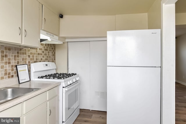 kitchen with tasteful backsplash, white cabinetry, dark hardwood / wood-style floors, and white appliances