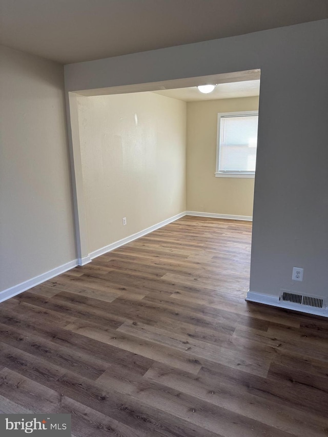 unfurnished room with dark wood-type flooring