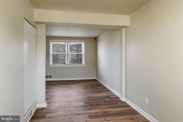 unfurnished room with dark wood-type flooring