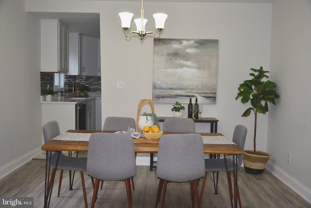 dining space with baseboards, dark wood finished floors, and a chandelier