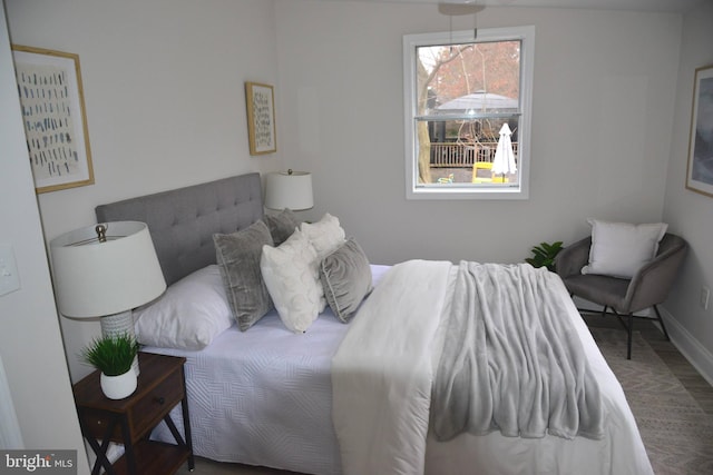 bedroom with baseboards and wood finished floors