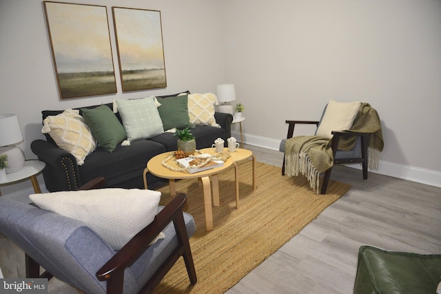 living area featuring baseboards and wood finished floors