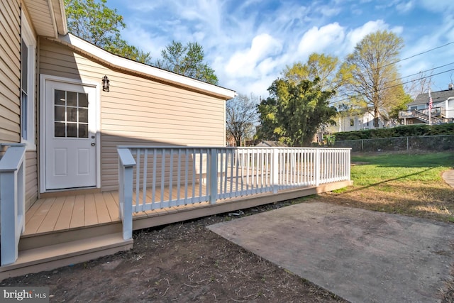 wooden terrace featuring a yard, a patio area, and fence