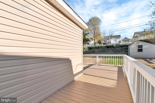 deck featuring an outbuilding, fence, and a storage unit