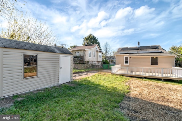 view of yard with a storage shed, an outdoor structure, a wooden deck, and fence