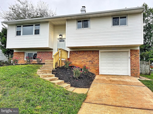 bi-level home with a garage and a front lawn