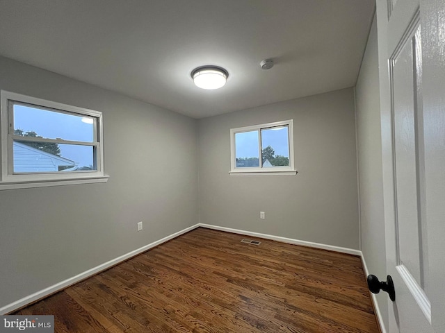 empty room with dark hardwood / wood-style floors