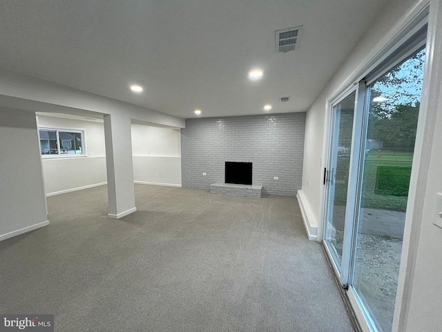 basement featuring a brick fireplace and carpet floors