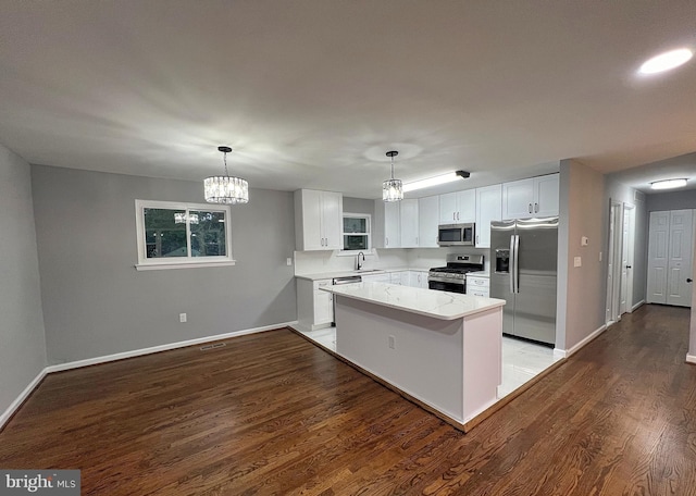 kitchen with hanging light fixtures, white cabinetry, appliances with stainless steel finishes, and an inviting chandelier