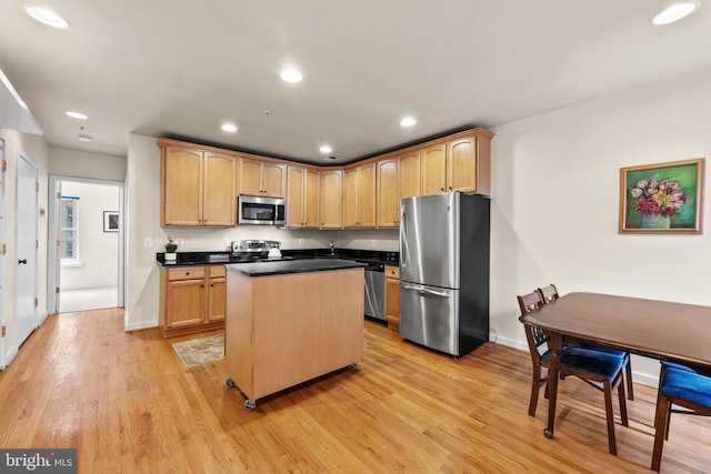 kitchen with light brown cabinets, light hardwood / wood-style floors, a center island, and appliances with stainless steel finishes