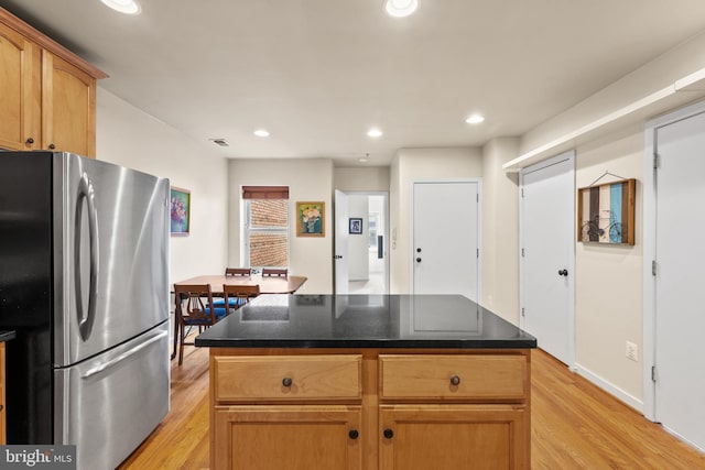 kitchen featuring a center island, stainless steel refrigerator, and light hardwood / wood-style flooring