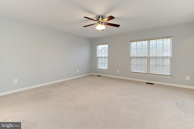 carpeted spare room featuring ceiling fan