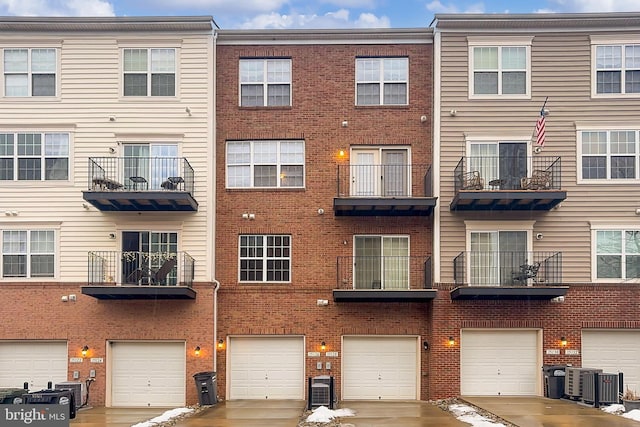 townhome / multi-family property featuring cooling unit and a garage