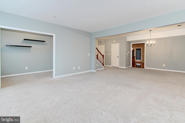 carpeted empty room with a notable chandelier