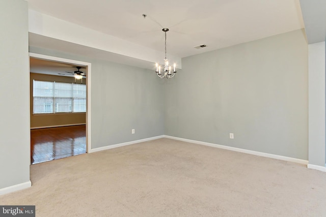 empty room with carpet flooring and ceiling fan with notable chandelier