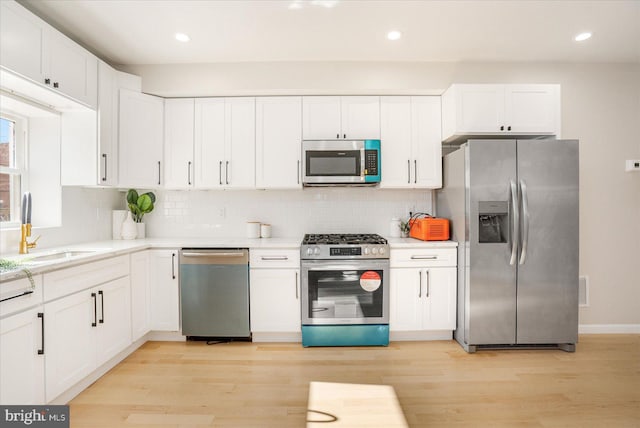 kitchen with sink, stainless steel appliances, light hardwood / wood-style floors, and white cabinets