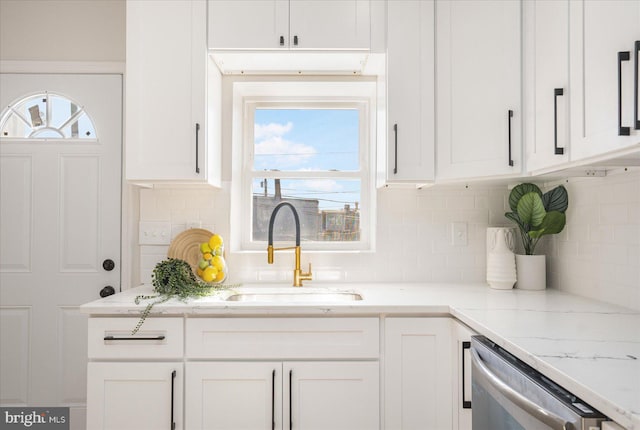 kitchen featuring white cabinetry, sink, stainless steel dishwasher, and a healthy amount of sunlight