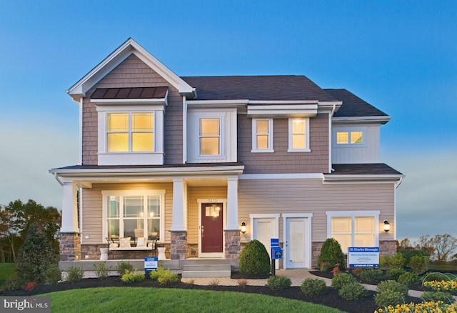 craftsman-style home featuring covered porch and a lawn