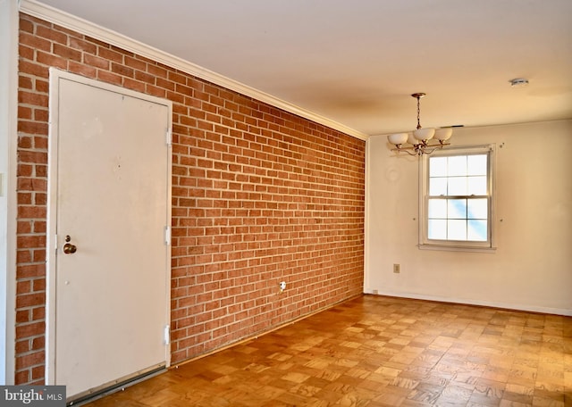 empty room featuring a notable chandelier, ornamental molding, light parquet flooring, and brick wall