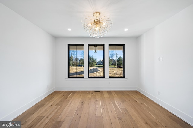 unfurnished dining area with light hardwood / wood-style floors and a notable chandelier