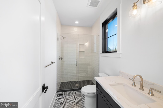 bathroom featuring vanity, toilet, and a shower with door