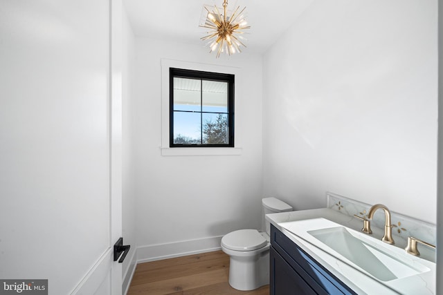 bathroom with vanity, hardwood / wood-style flooring, toilet, and an inviting chandelier