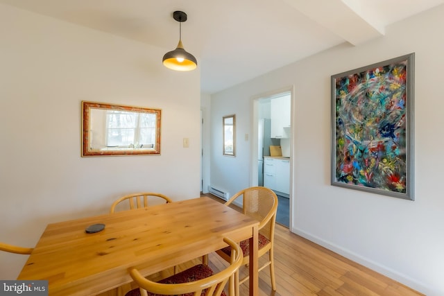 dining room featuring a baseboard heating unit and light wood-type flooring