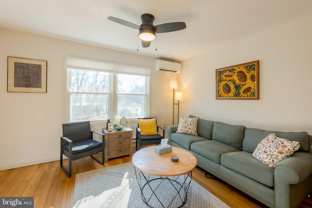 living room featuring ceiling fan, a wall mounted air conditioner, and light hardwood / wood-style floors