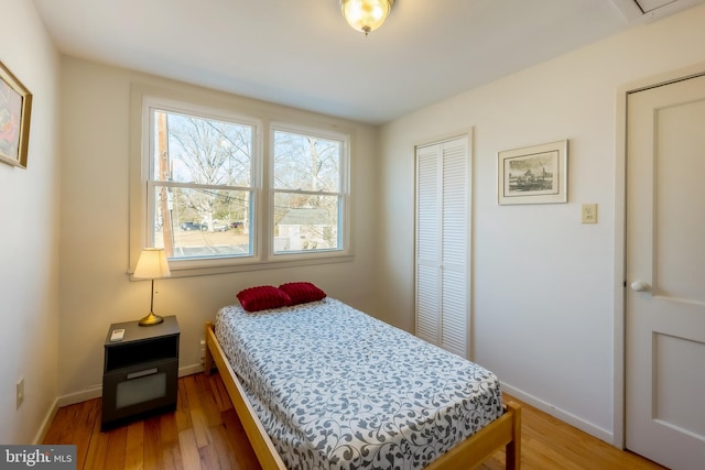 bedroom with hardwood / wood-style floors and a closet