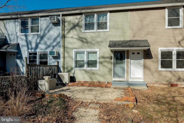 rear view of property with a wall mounted air conditioner and ac unit