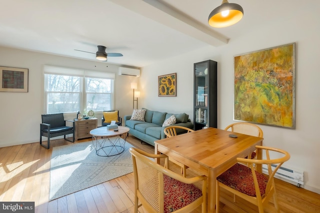 interior space with a wall unit AC, light wood-type flooring, a baseboard heating unit, ceiling fan, and beam ceiling