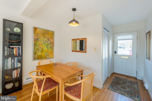 dining room with baseboard heating and light hardwood / wood-style flooring