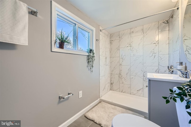 bathroom featuring tiled shower, vanity, toilet, and tile patterned floors