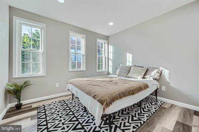 bedroom featuring hardwood / wood-style flooring and multiple windows