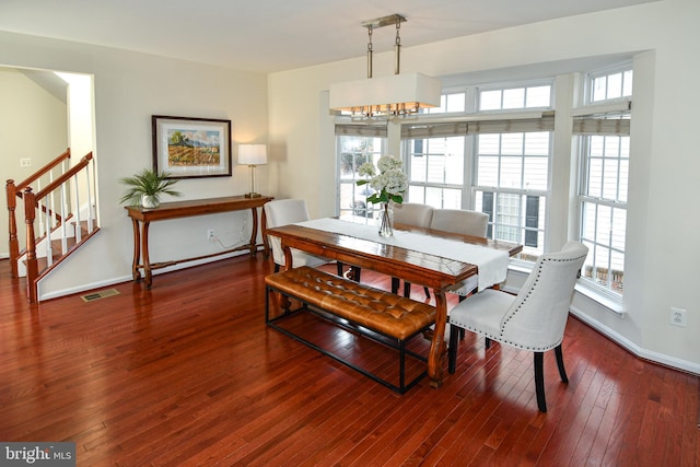 dining area featuring wood-type flooring and an inviting chandelier