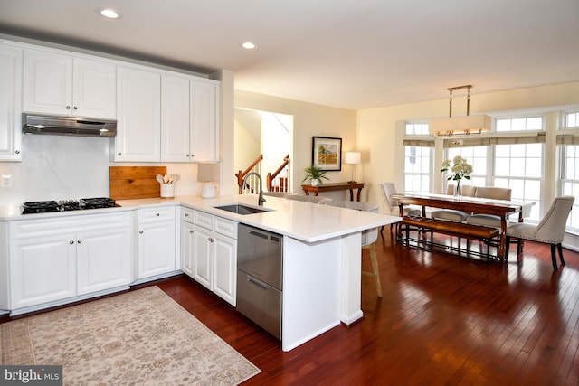 kitchen with hanging light fixtures, white cabinetry, and kitchen peninsula