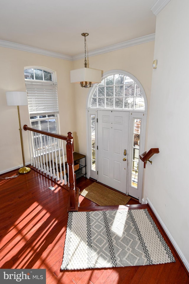 entrance foyer with crown molding, hardwood / wood-style floors, and an inviting chandelier