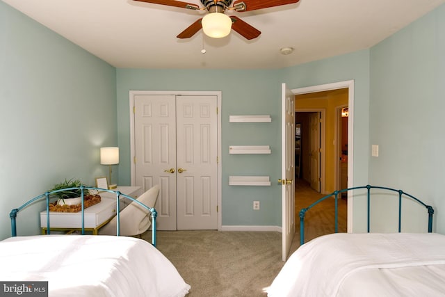 carpeted bedroom featuring ceiling fan and a closet