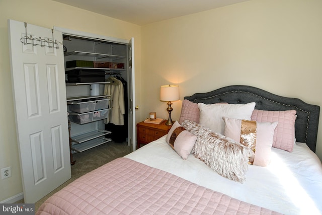 bedroom with dark carpet, a walk in closet, and a closet