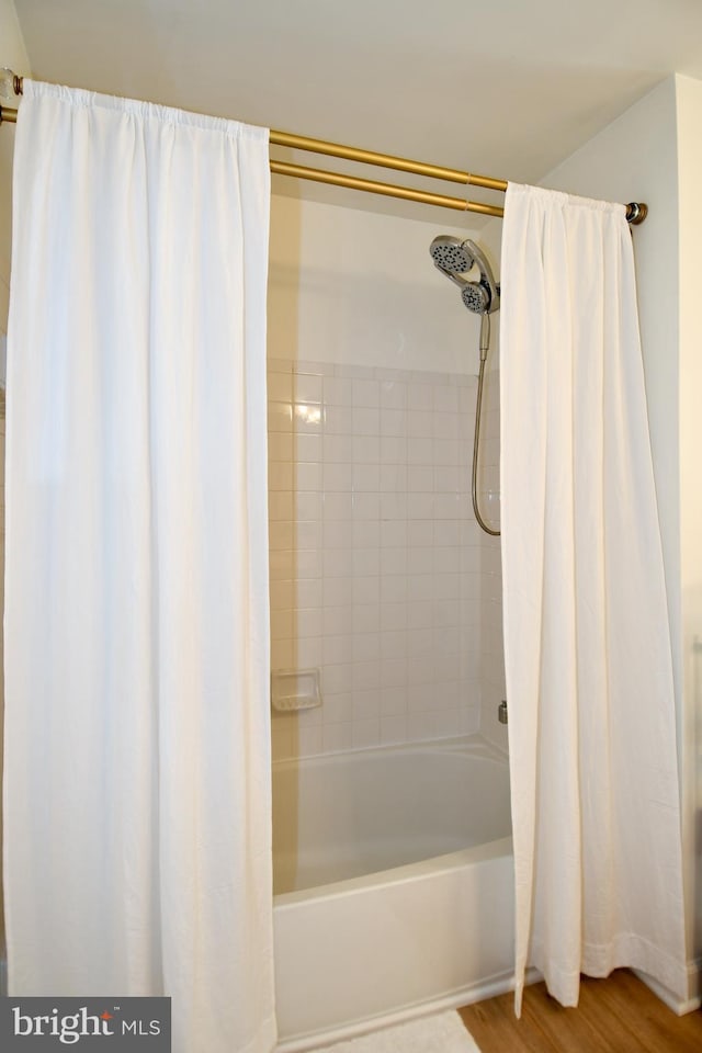 bathroom with hardwood / wood-style floors and shower / bath combo