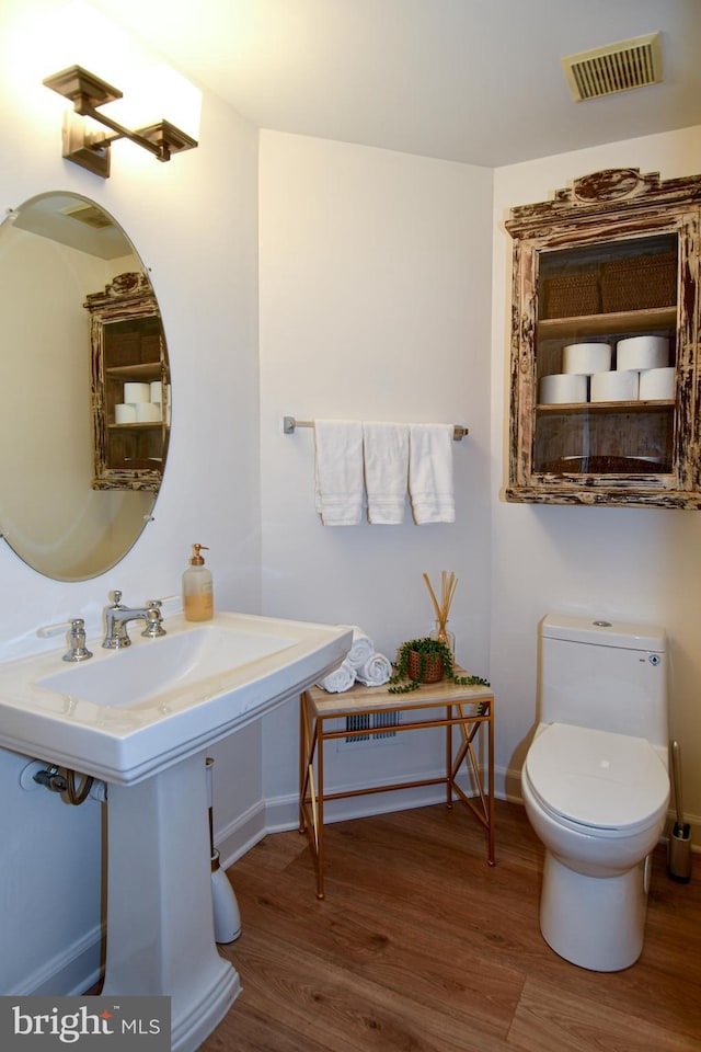 bathroom featuring wood-type flooring and toilet