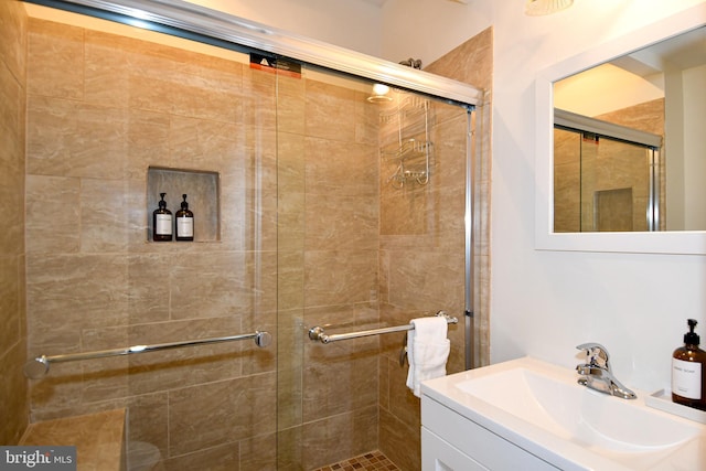 bathroom with vanity and a shower with door