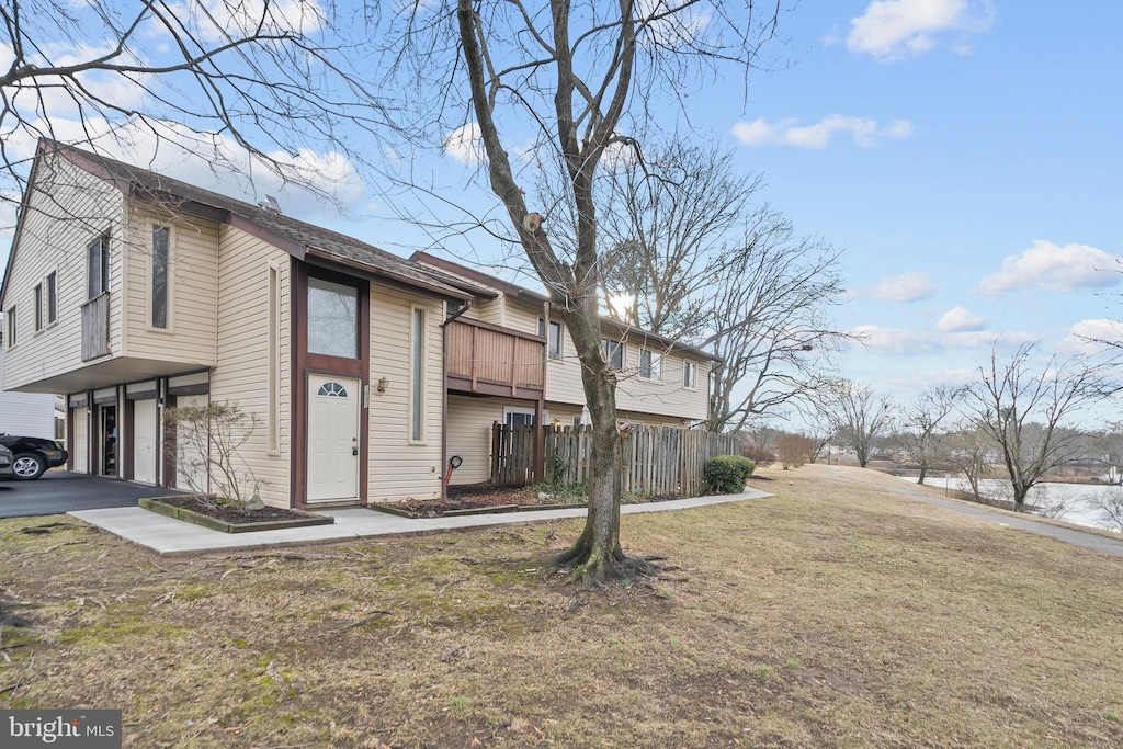 view of front of property featuring a balcony and a front lawn