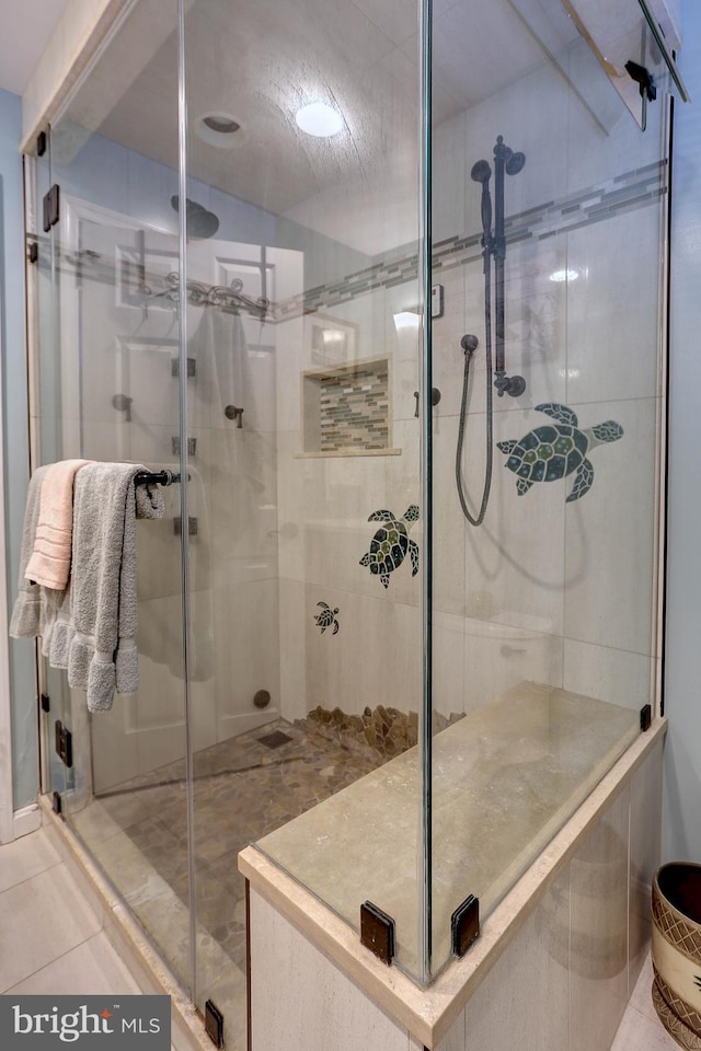 bathroom with tile patterned floors and an enclosed shower